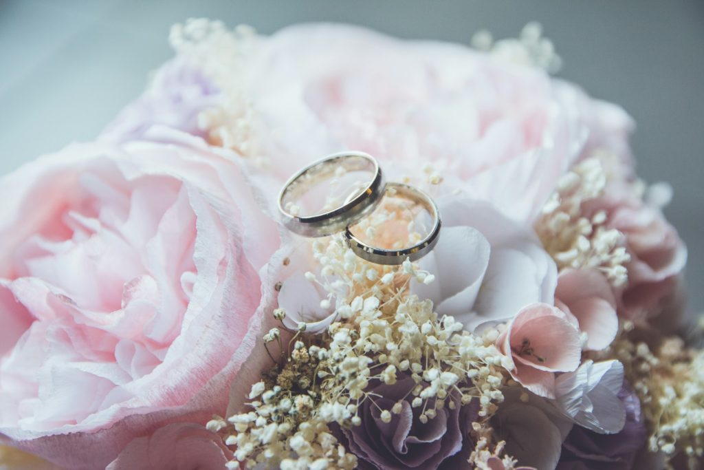 Bridal ring set placed on a pink rose bouquet