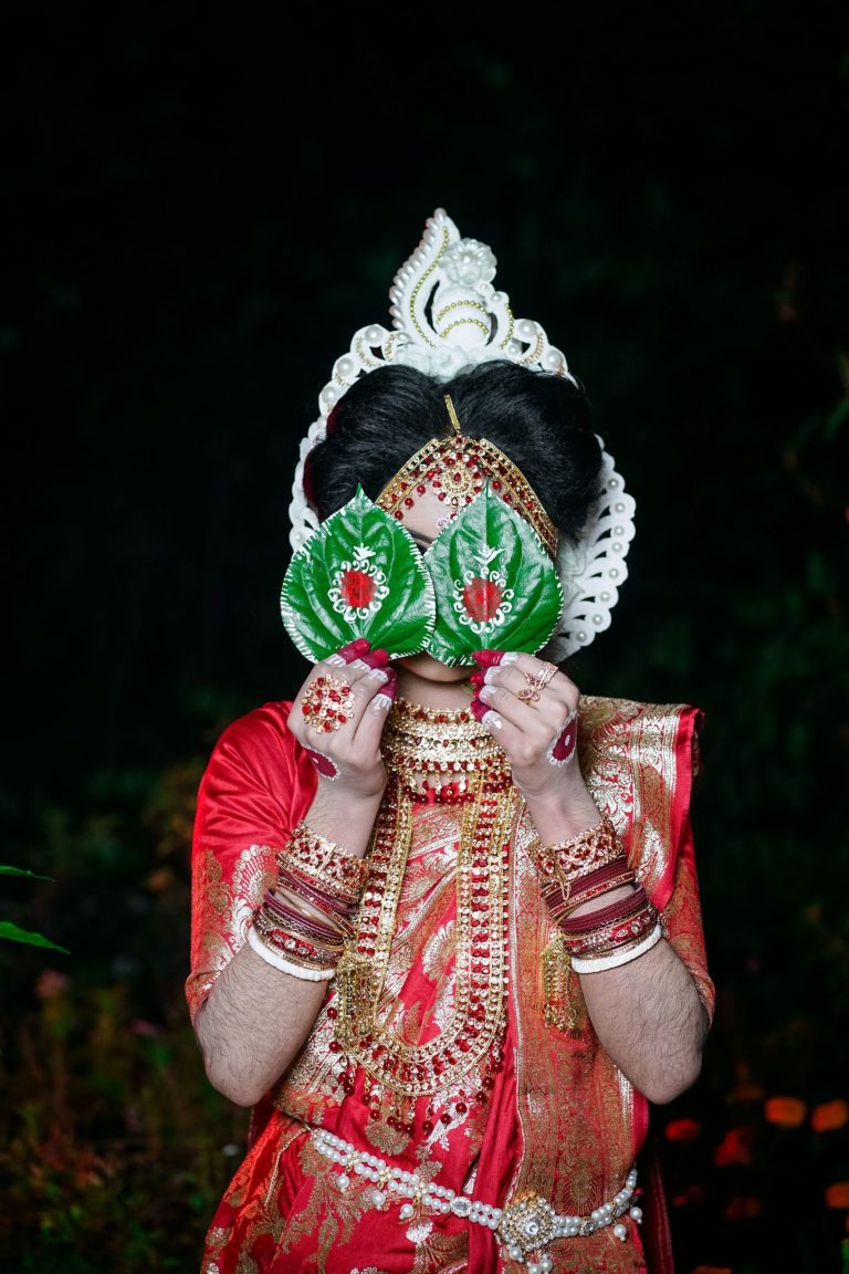 Bride shielding her face with leaves in a traditional wedding ritual