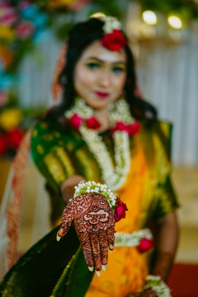 Close-up of a bride showing intricate mehndi on her hand