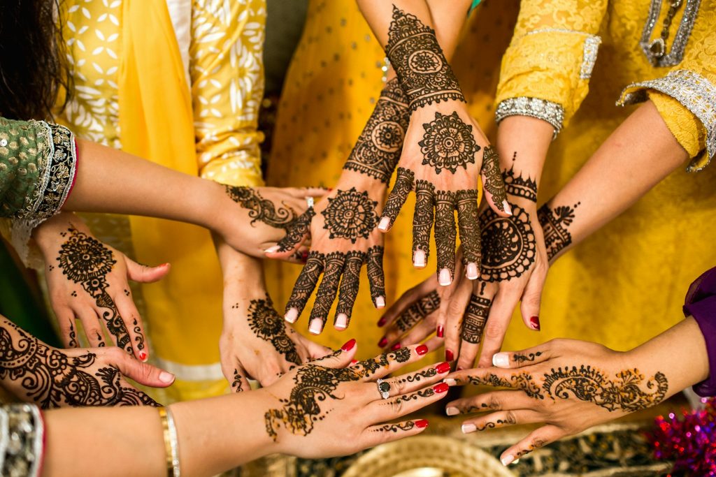 Group of hands decorated with intricate henna patterns