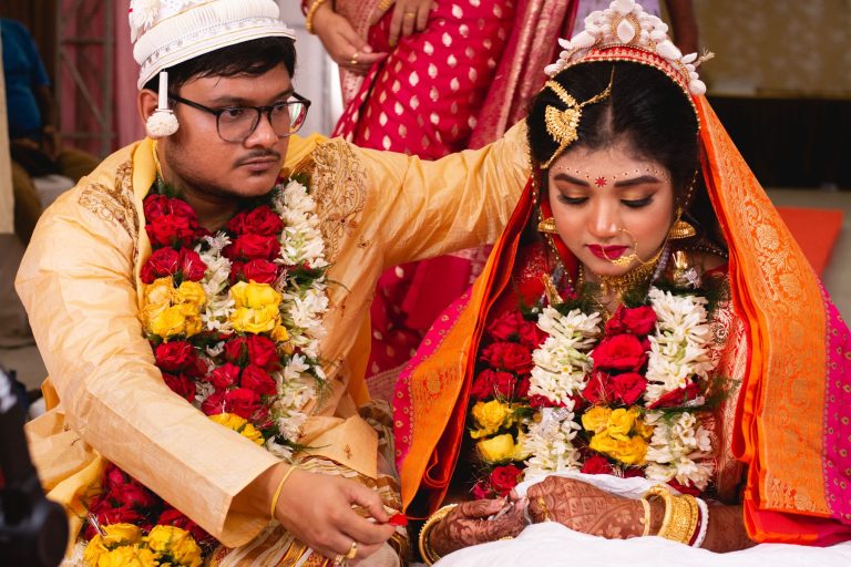 Newlywed couple wearing floral garlands during their ceremony